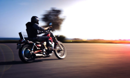 Un motard roulant face au couché de soleil